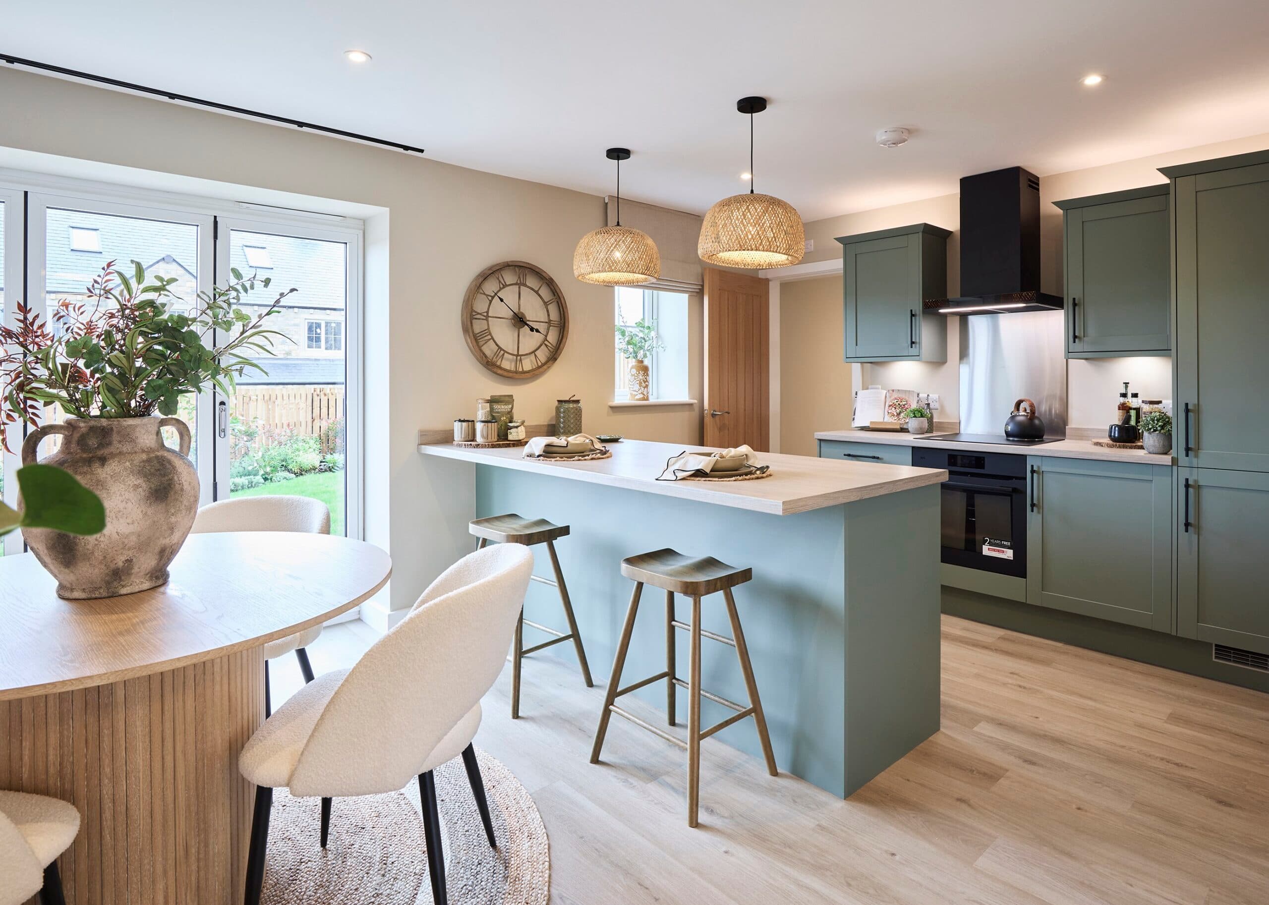 A muted green kitchen at Pendle Farm in Worsthorne featuring bi fold doors