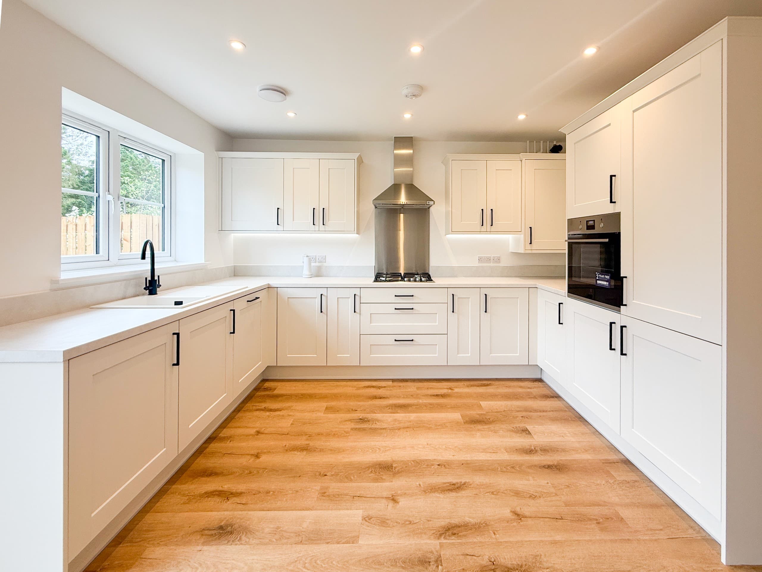 Shaker-style fitted kitchen in The Hawcliffe, featuring light cabinetry, dark handles and integrated appliances